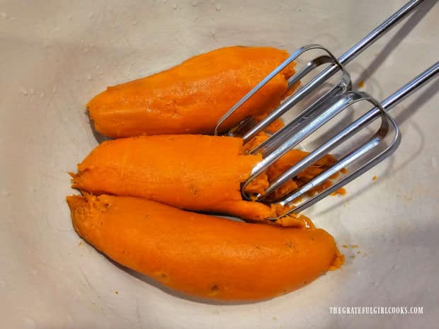 An electric mixer is used to beat the sweet potatoes until creamy.