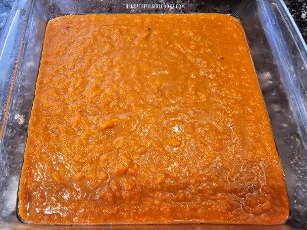 Mashed sweet potatoes are spread into a greased baking dish.