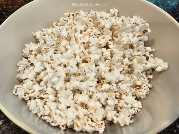 Taco Popcorn - The Grateful Girl Cooks! Twelve cups of plain popped popcorn are placed in a large mixing bowl.