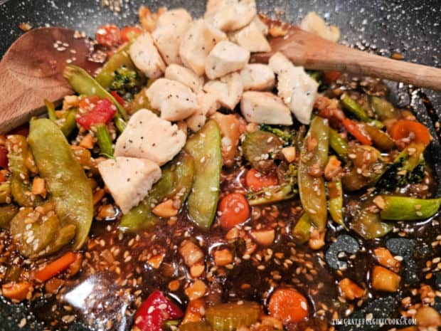 Cooked chicken is added to the stir-fried veggies and sauce and combined.