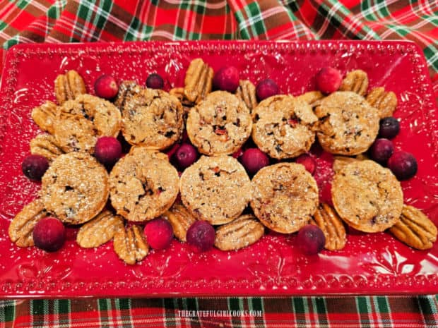 A red platter is used to serve some of the cranberry pecan tassies.
