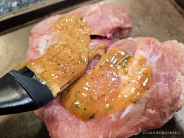 A pastry brush is used to brush the sauce on the pork on all sides.
