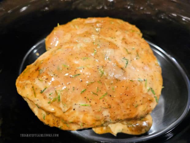 Fully seasoned and chilled pork butt is added to a crockpot for low, slow cooking.