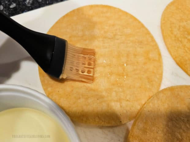 A pastry brush is used to brush each tortilla with oil.