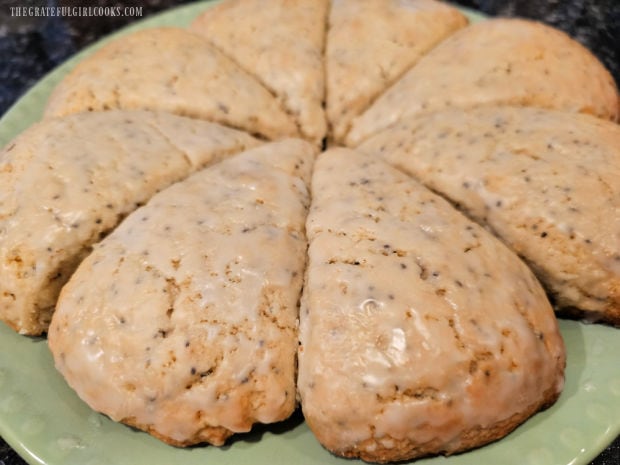 A green plate holding 8 lemon poppyseed scones, ready to be eaten.