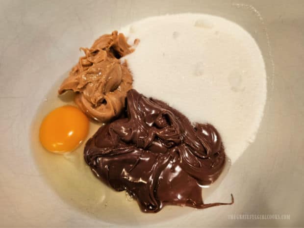 Peanut Butter and Nutella Cookies - The Grateful Girl Cooks! Egg, sugar, peanut butter and Nutella are measured into a mixing bowl.