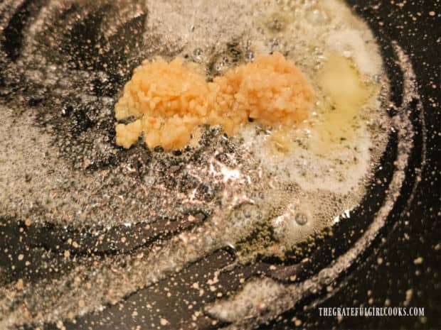 Butter and garlic are heated in a large skillet before cooking the shrimp.