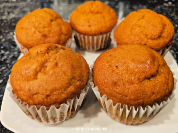 Five of the easy pumpkin muffins for two are served on a white plate.