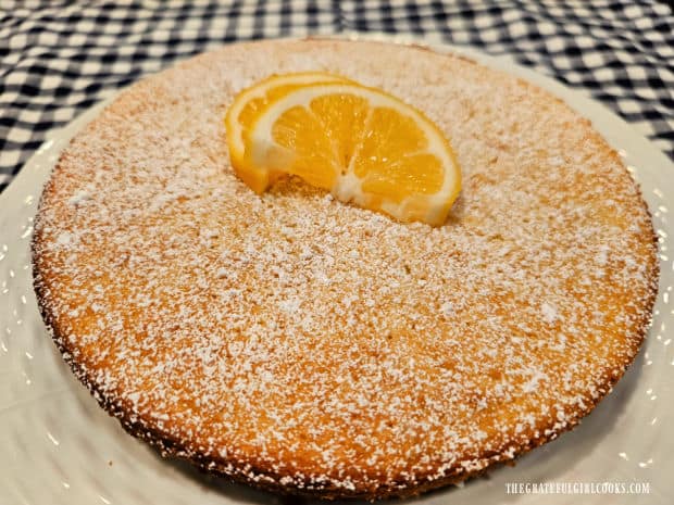 Lemon olive oil cake, dusted with powdered sugar and decorated with lemon slices.