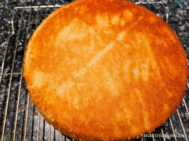 The parchment paper is removed revealing the baked cake underneath.