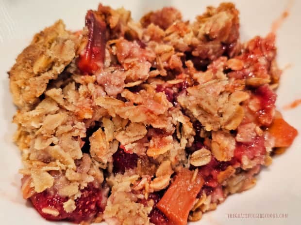 A serving of air fryer strawberry rhubarb crisp is served in a small bowl.