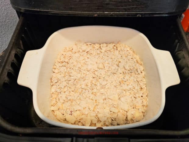 Dish holding the fruit crisp is placed in a preheated air fryer basket.
