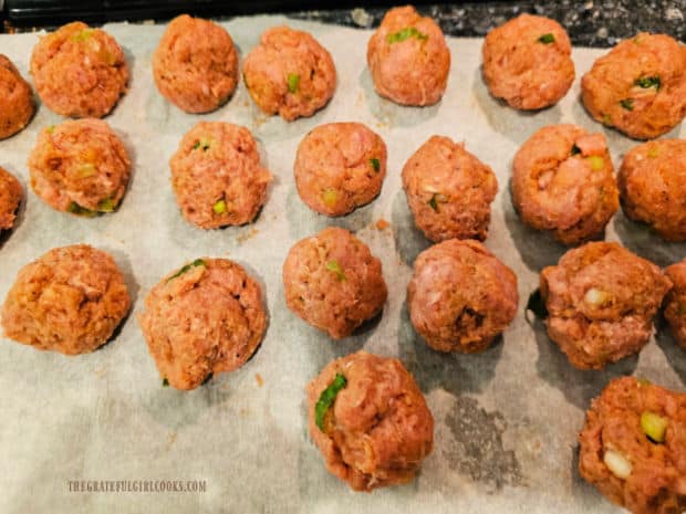 Turkey meatballs are placed on parchment paper after they are shaped.