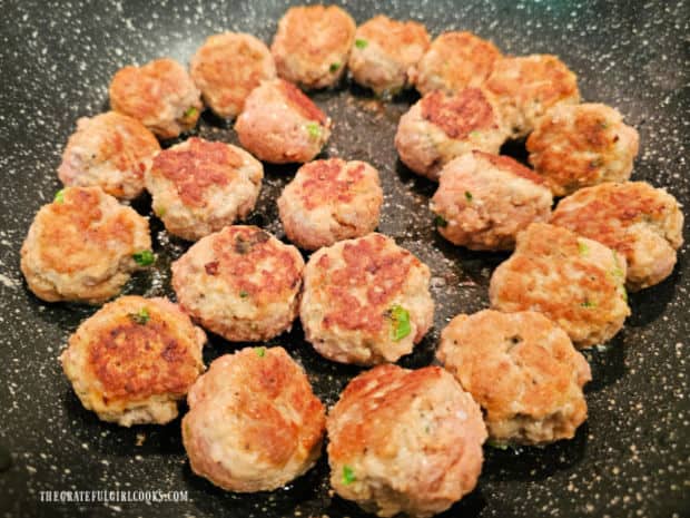 Meatballs are cooked and browned on all sides in in a large skillet.