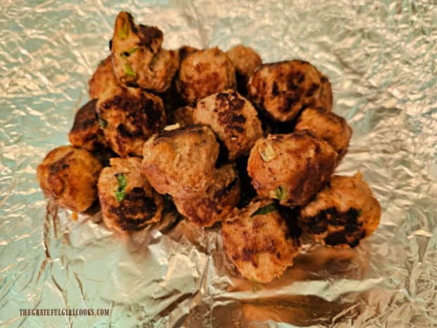 After they're cooked, meatballs are wrapped in aluminum foil to keep warm.
