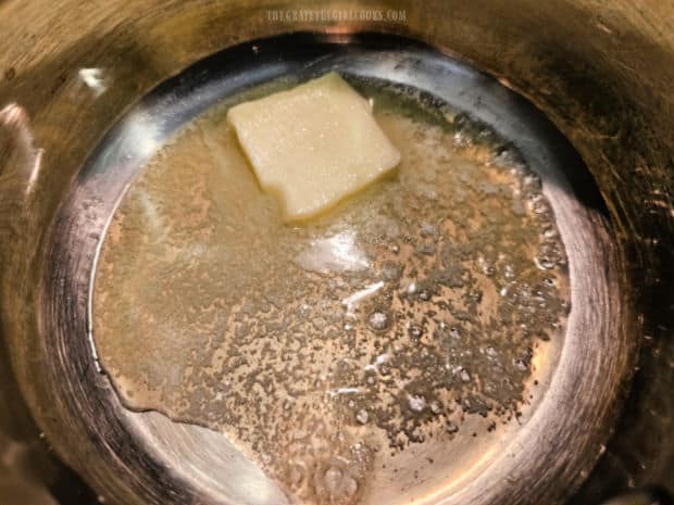 Butter is melted in a saucepan to begin making the cheese sauce.