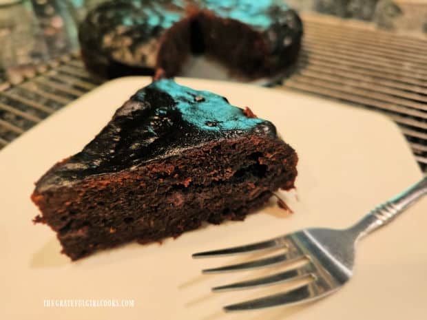 One slice of chocolate zucchini cake (Instant Pot) on a white plate.