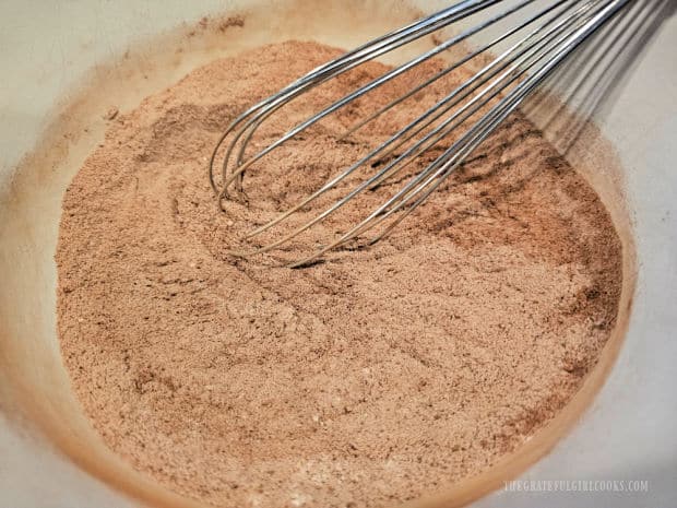 Dry ingredients for the cake are whisked together in a bowl.