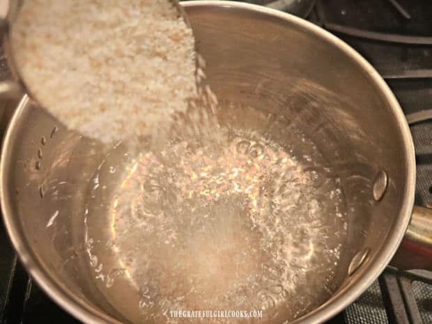 Egg Topped Cheesy Grits - The Grateful Girl Cooks! Quick cooking grits are added to a pan of salted, boiling water.