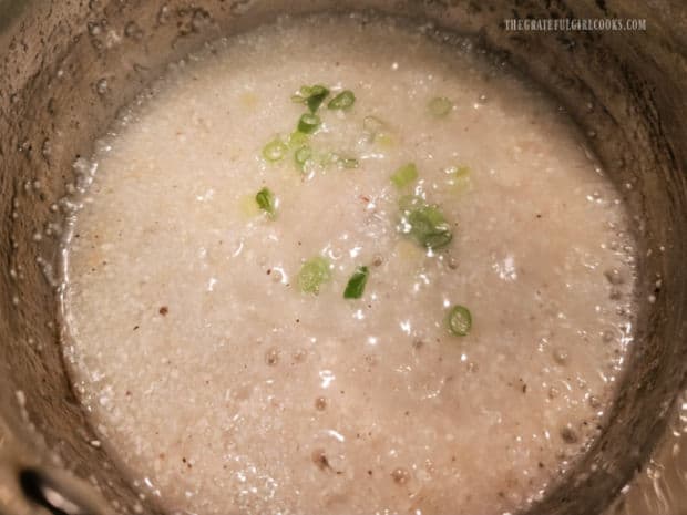 Egg Topped Cheesy Grits - The Grateful Girl Cooks! Thinly sliced green onions and garlic powder are added to the pan of grits.