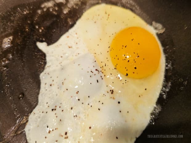 Egg Topped Cheesy Grits - The Grateful Girl Cooks! One large egg is fried to garnish the top of the cheesy grits.