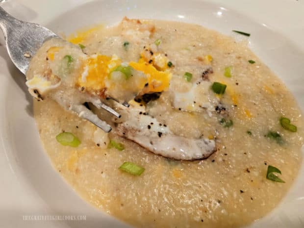 Egg Topped Cheesy Grits - The Grateful Girl Cooks! A forkful of fried egg and grits held over the bowl.