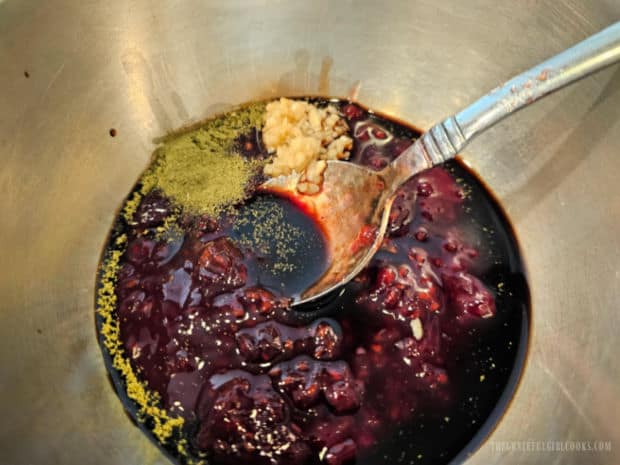Raspberry jam, thyme, garlic and balsamic vinegar placed into a small bowl.