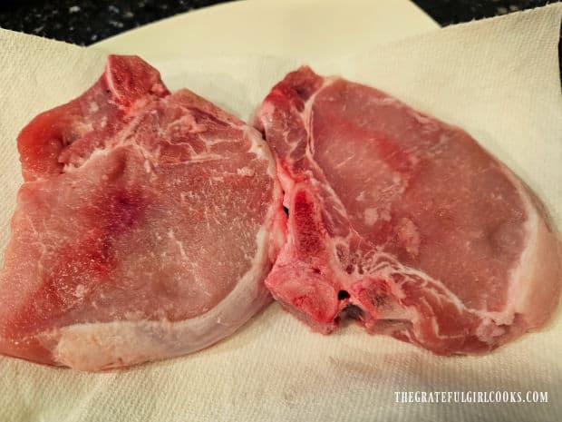 Two bone-in pork chops (1" thick) are patted dry with paper towels.