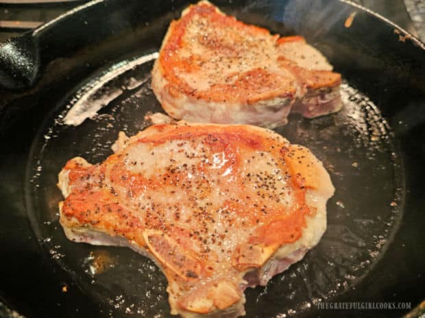 Pork chops are flipped over to brown/cook the other side.