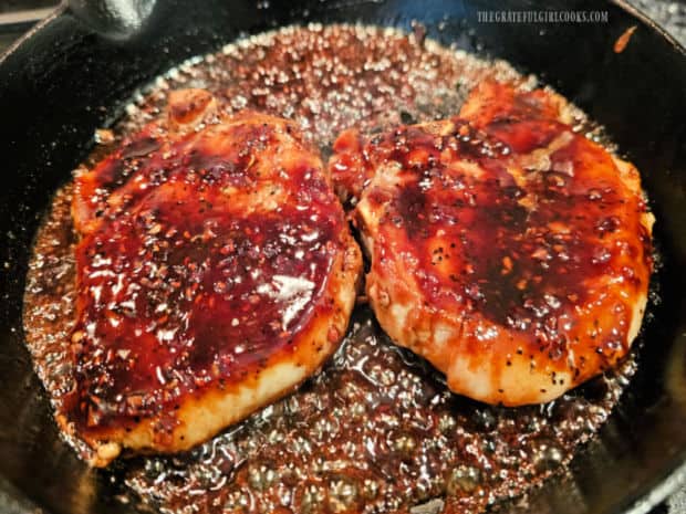 Raspberry balsamic sauce is spooned over the chops in the skillet, to coat.