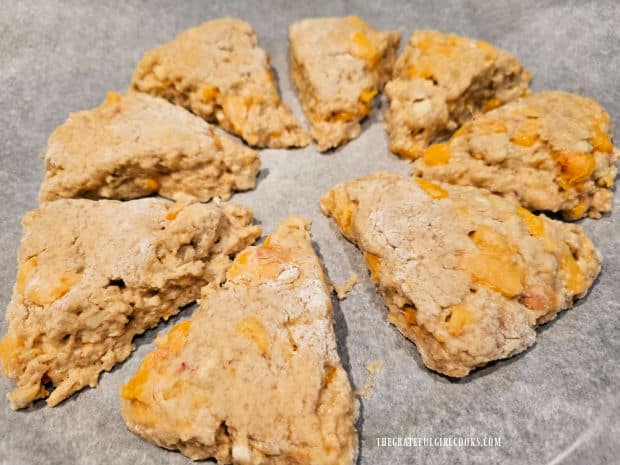Glazed Peach Scones - The Grateful Girl Cooks! Pre-baked scone wedges are placed on parchment paper lined baking sheet.